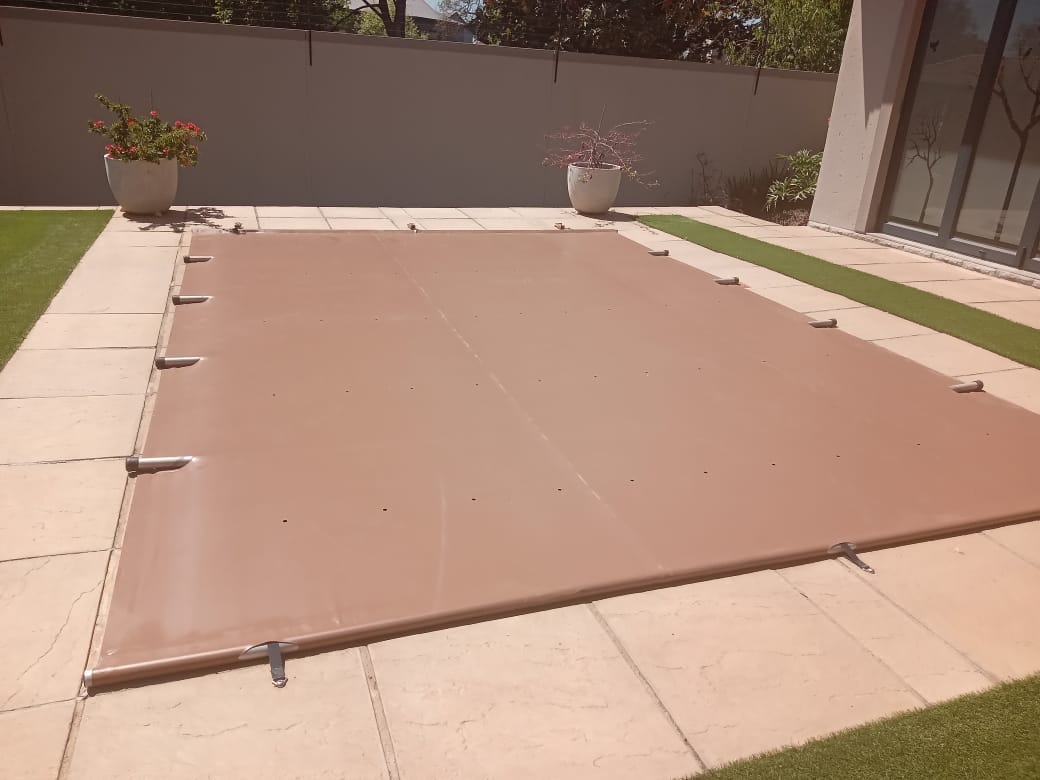 Tan fitted pool cover in a modern courtyard